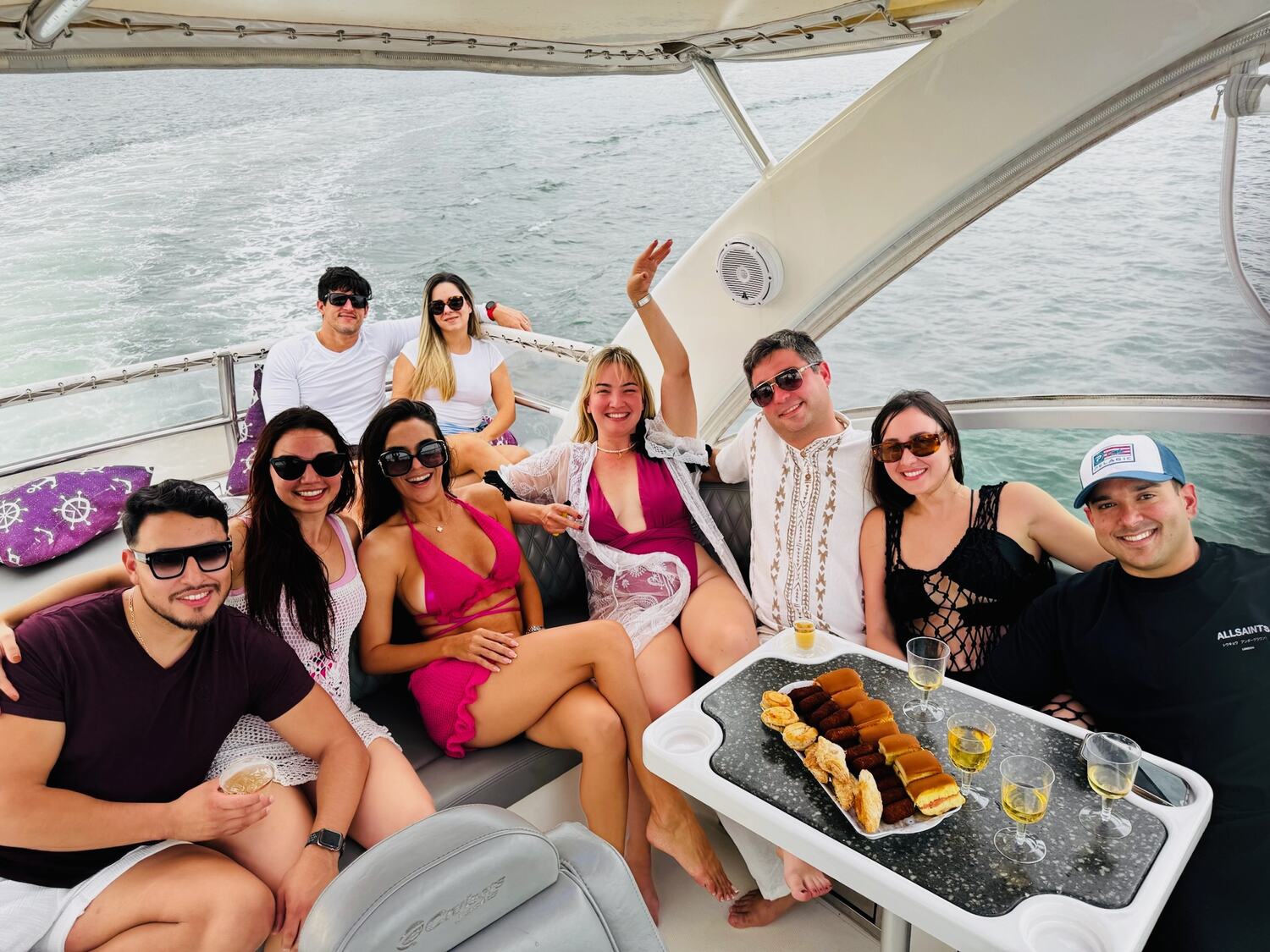 Friends toasting around the cockpit table with a charcuterie spread