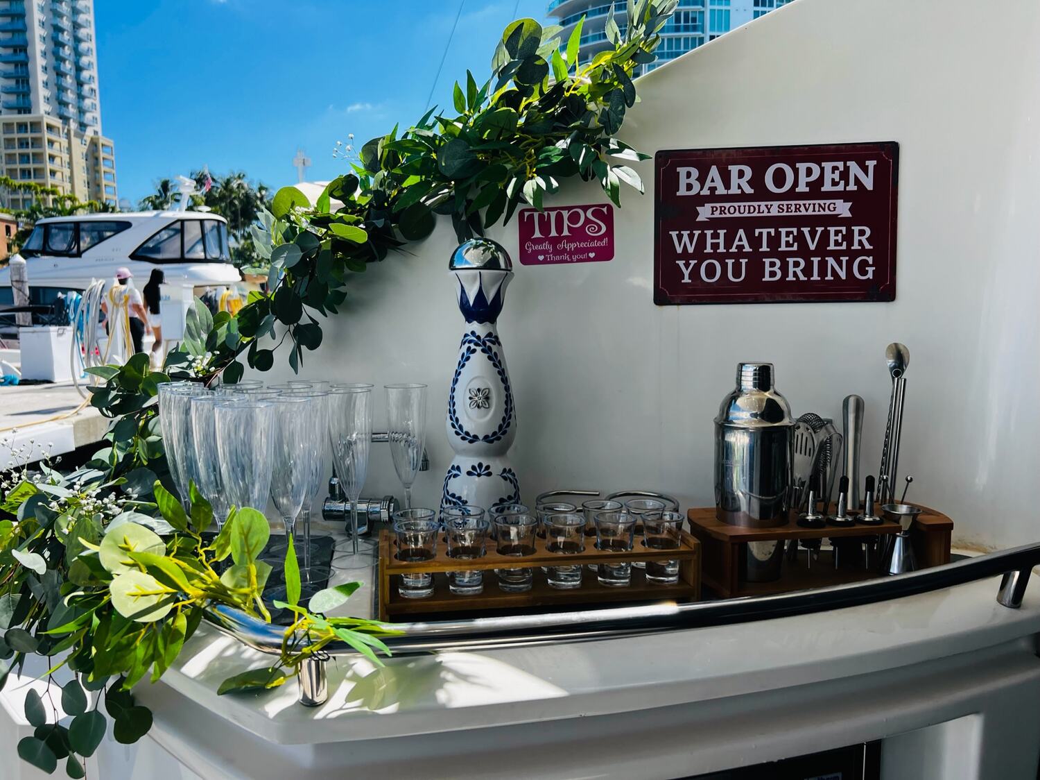 Onboard bar set up with tequila, glasses and a Bar Open sign