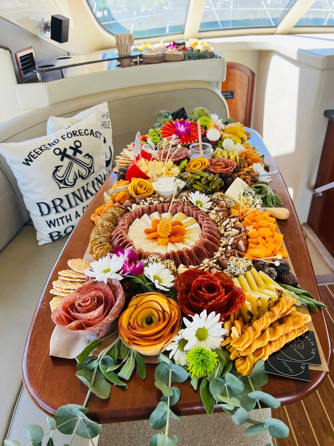 Catered charcuterie board with flowers laid out on the yacht table